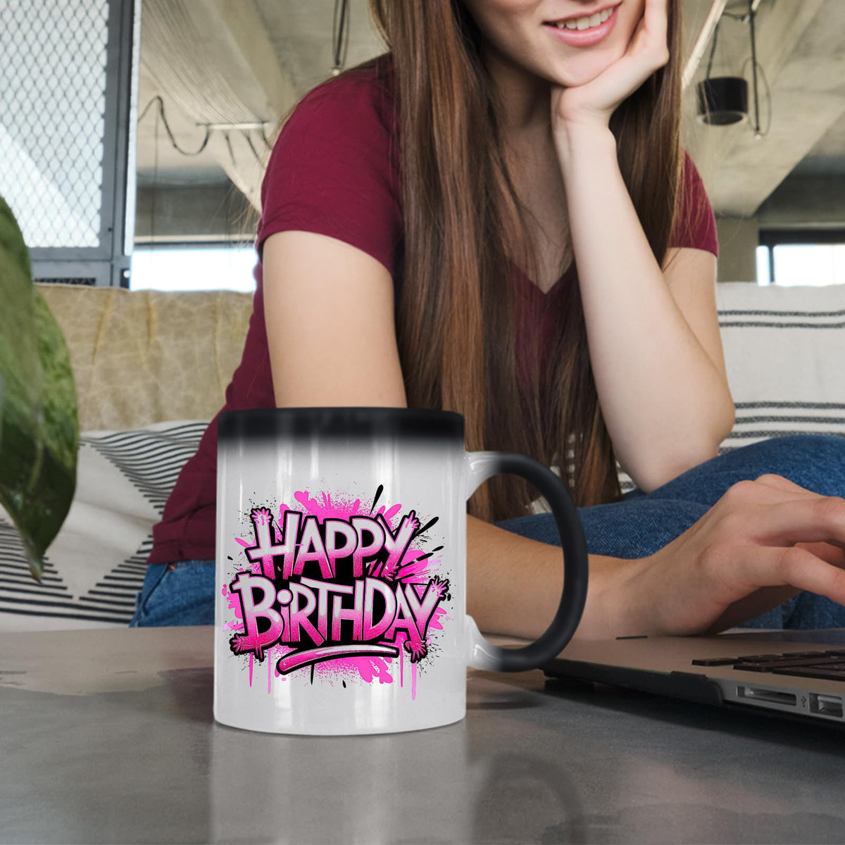 Woman at a laptop with the Happy Birthday pink graffiti colour changing mug