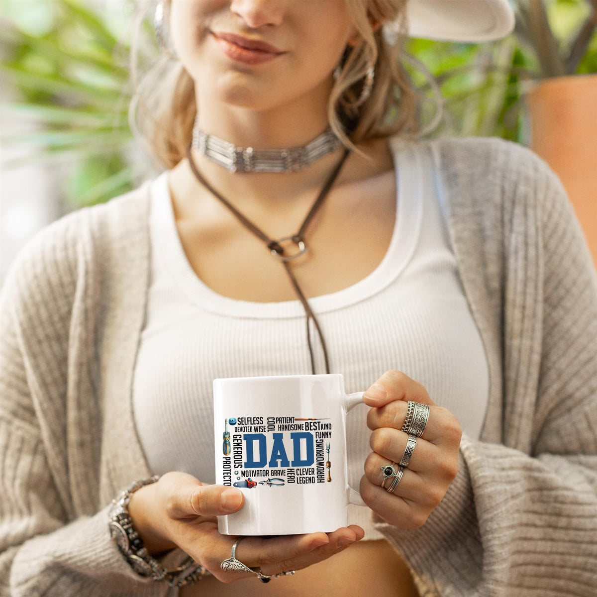 Woman in a cardigan holding the DAD word cloud mug