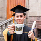 Graduate in cap and gown holding the Hunting Dad deer mug