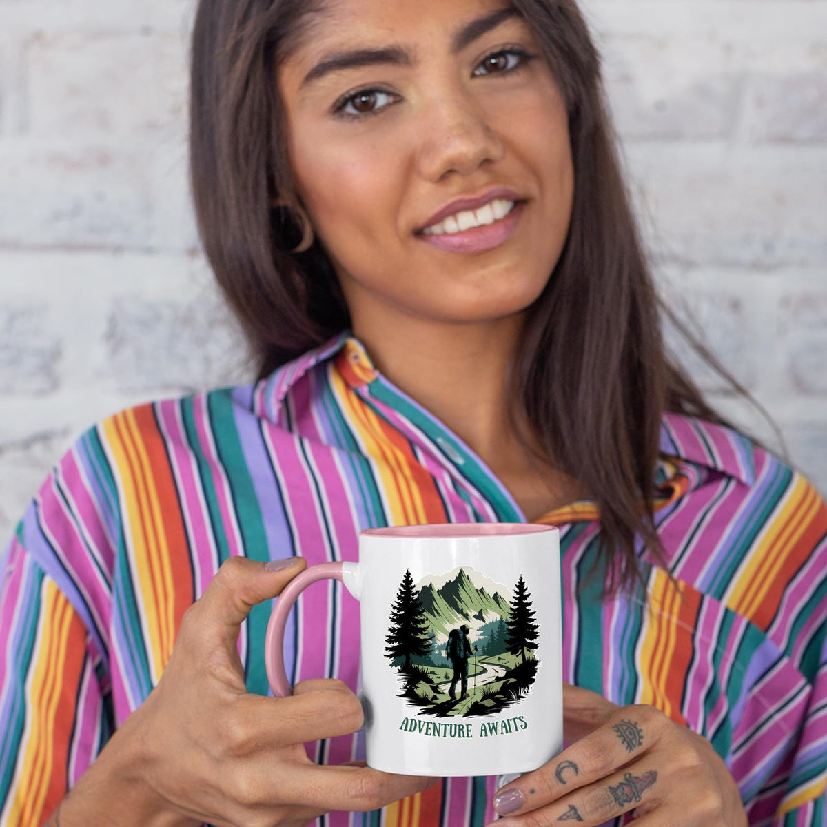 Woman in a striped shirt holding the Adventure Awaits hiker colour handle mug
