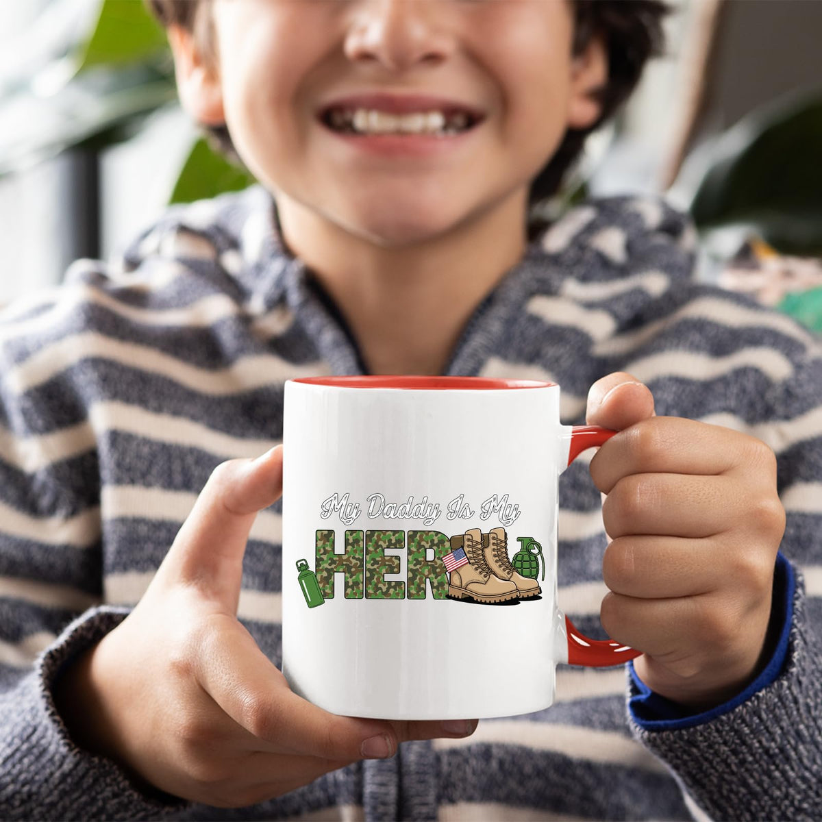 Smiling child holding the My Daddy Is My Hero military mug with a red handle