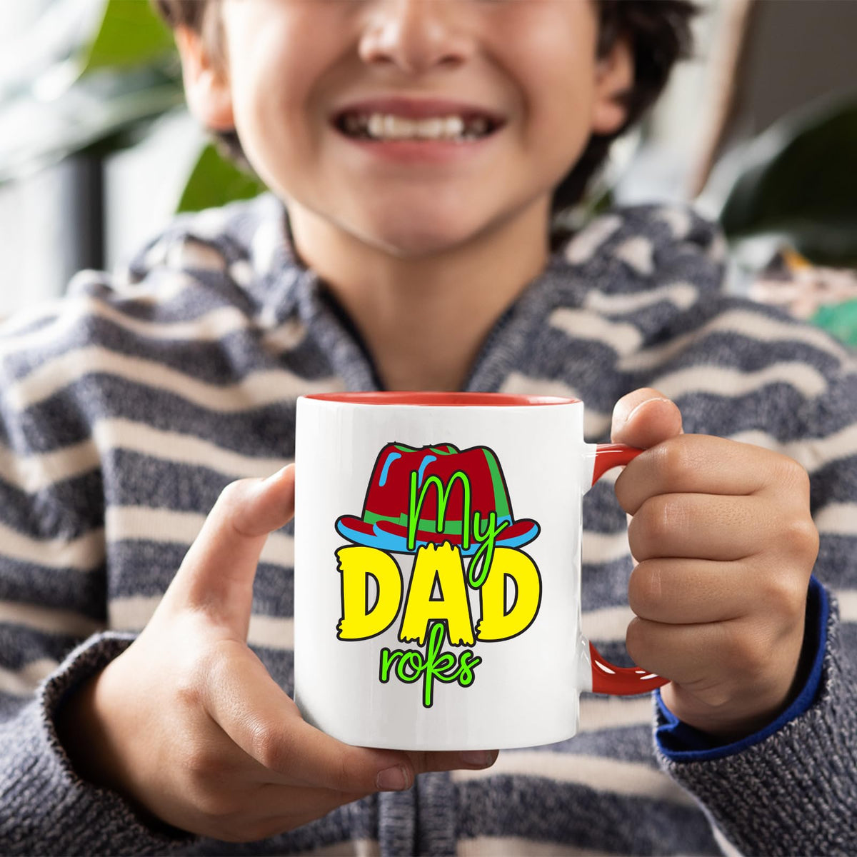 Boy holding a red handle mug with the colourful My Dad Rocks hat design