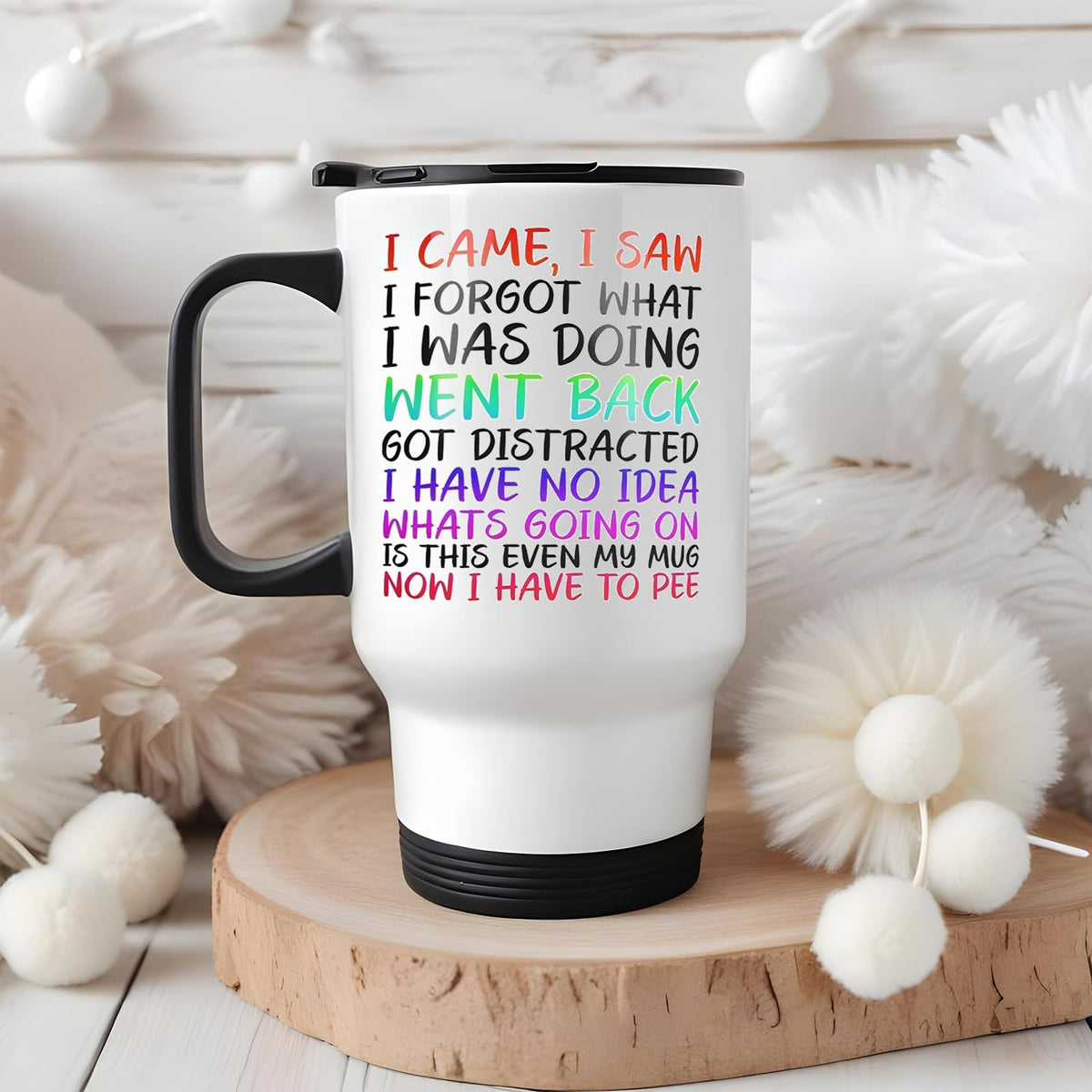 I Came I Saw I Forgot travel mug on a wooden slice with white pom-poms