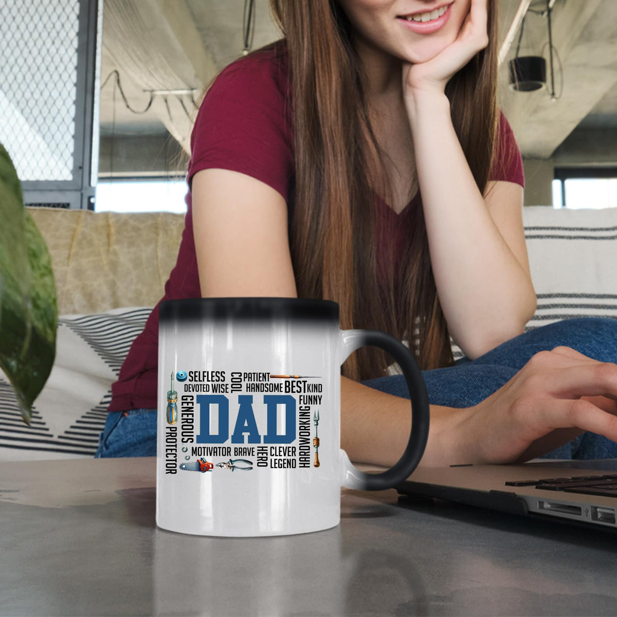 Woman at a laptop with the DAD word cloud colour changing mug