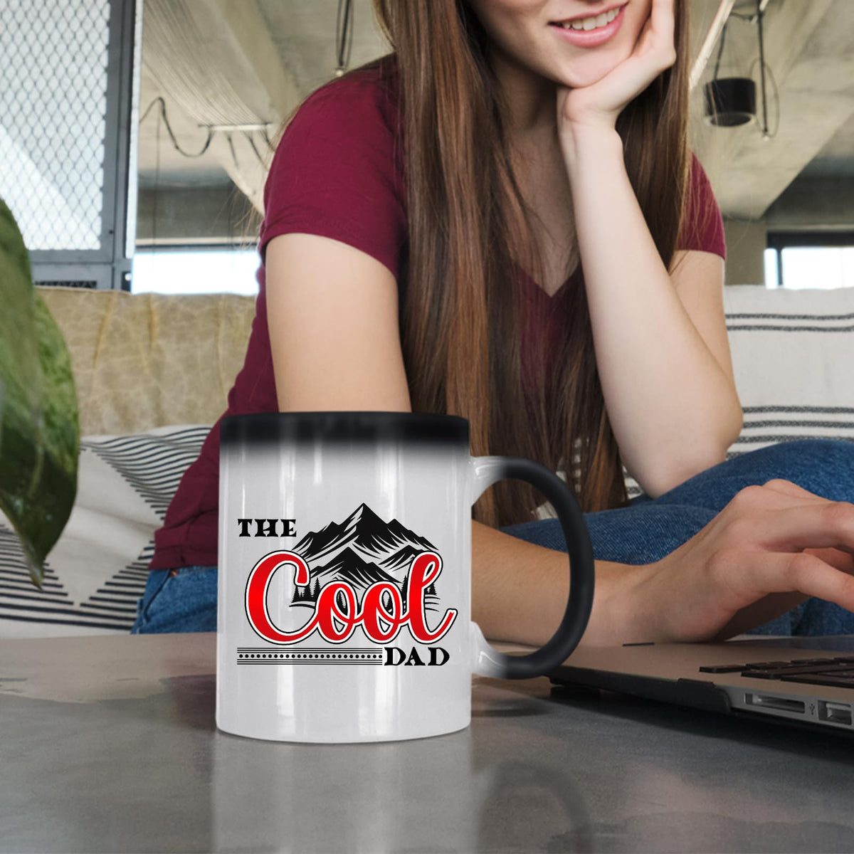 Woman at a laptop with the The Cool Dad mountains colour changing mug