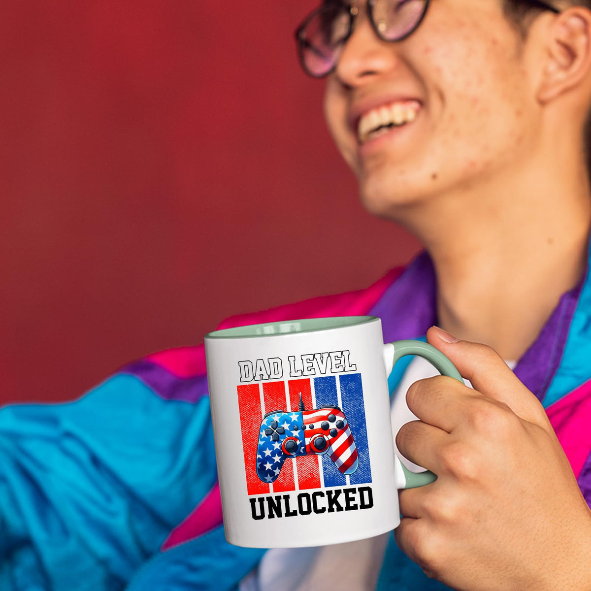 Smiling person in a colourful jacket holding the Dad Level Unlocked mug with a light green handle