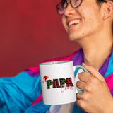 Smiling person in a colourful jacket holding the Papa Claus mug with a light green handle