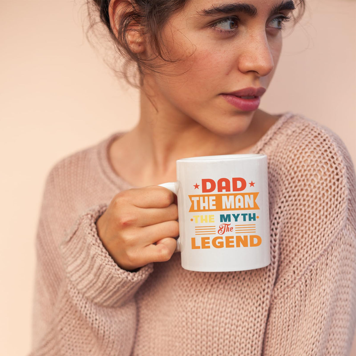 Woman in a pink jumper holding the Dad the Man retro mug