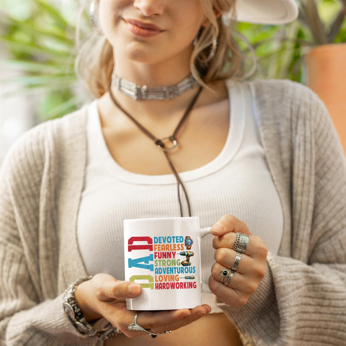 Woman in a cardigan holding the DAD Devoted mug