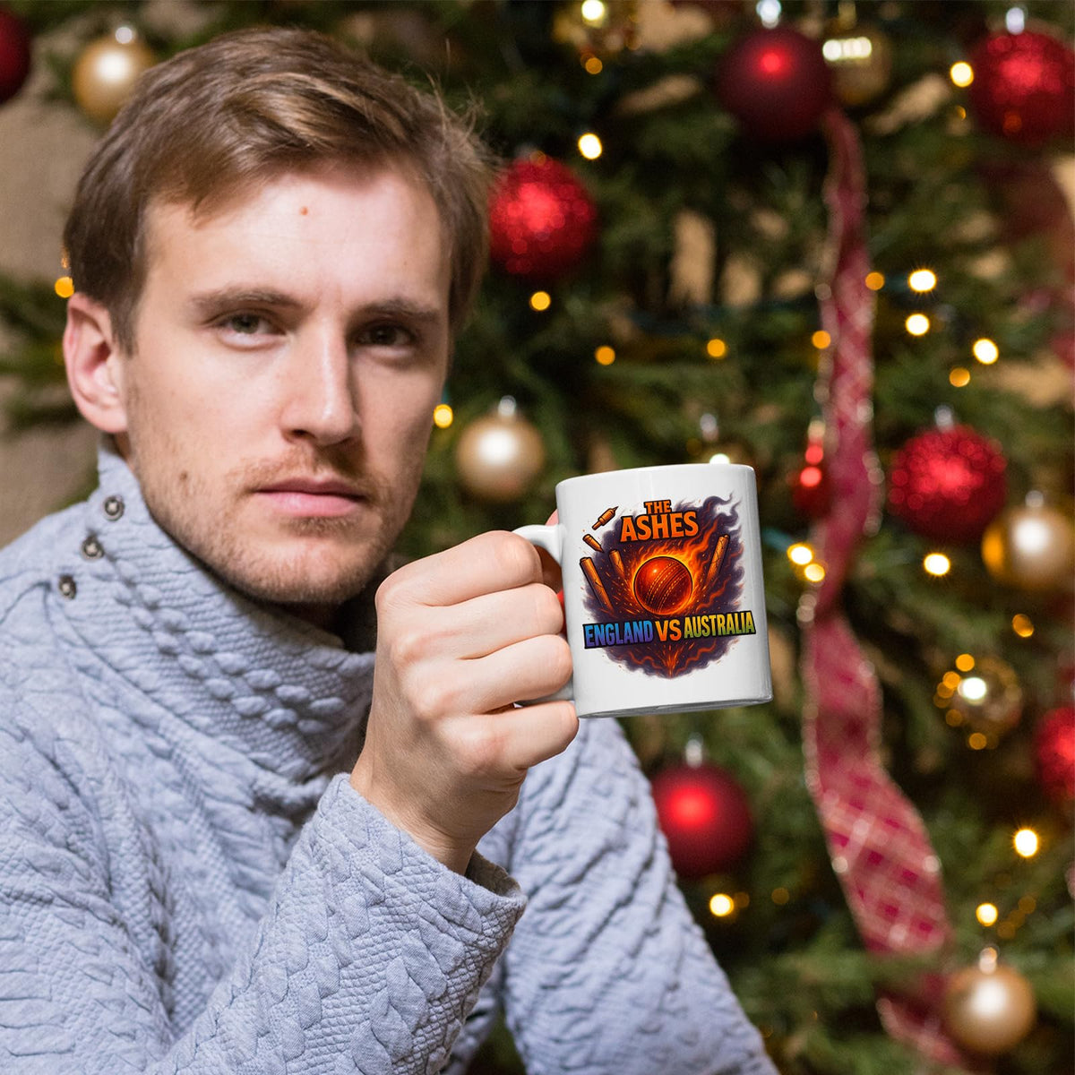 Man holding the Ashes cricket mug by a Christmas tree