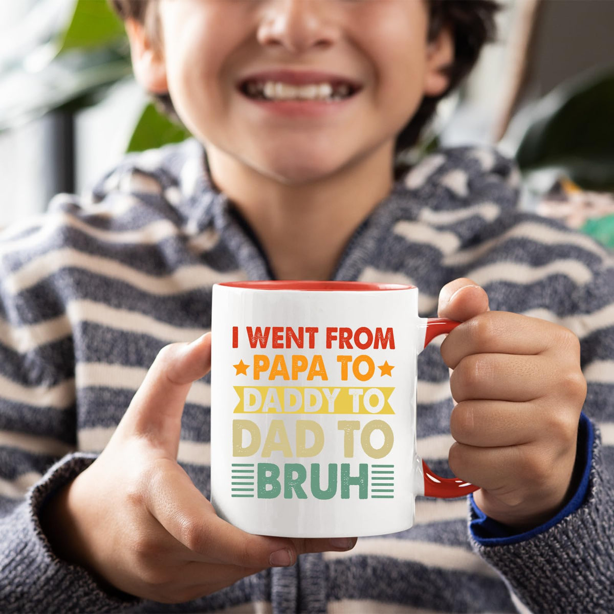 Smiling child holding the Papa to Bruh mug with a red handle