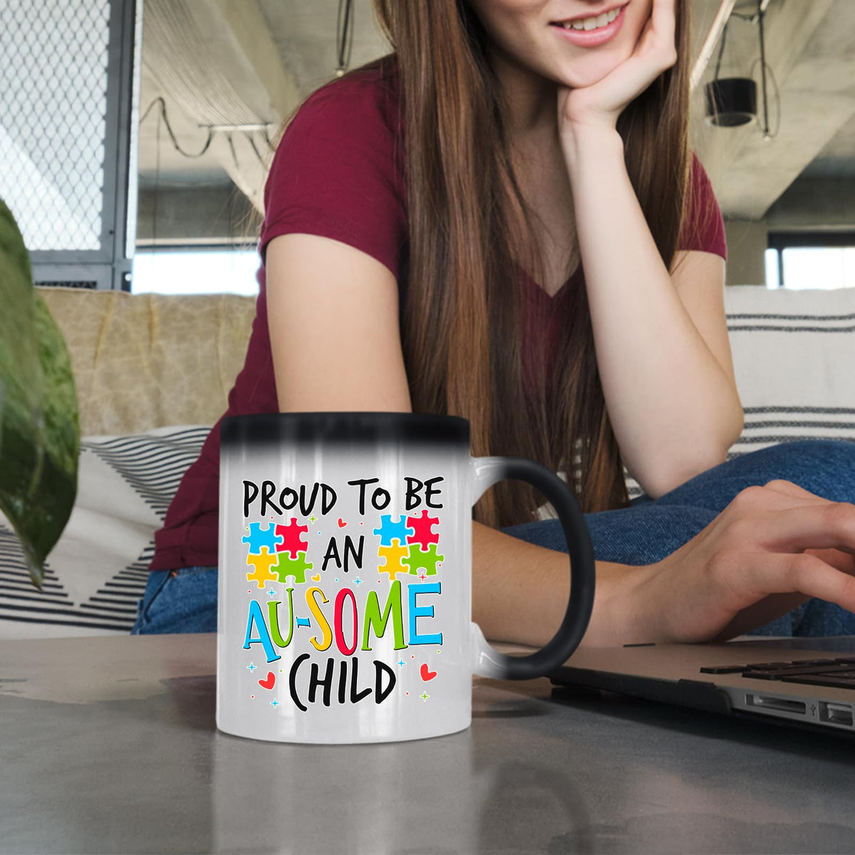 Woman at a laptop with the Proud to Be an Au-Some Child colour changing mug