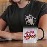 Happy Birthday pink splash colour changing mug on a desk beside a laptop