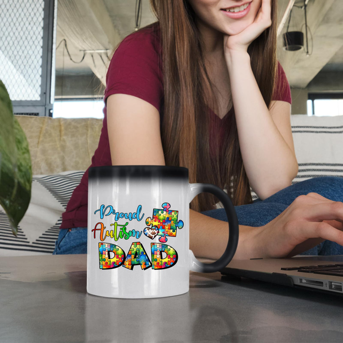 Woman at a laptop with the Proud Autism Dad colour changing mug