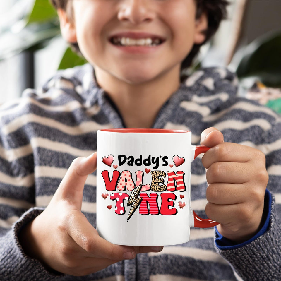 Smiling child holding the Daddy’s Valentine mug with a red handle