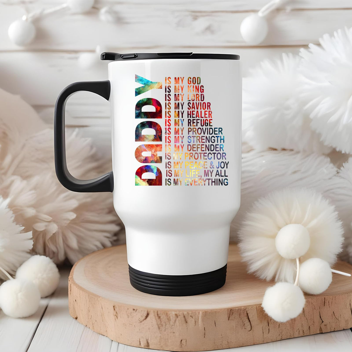 Daddy Is My God travel mug on a wooden slice with white pom-poms