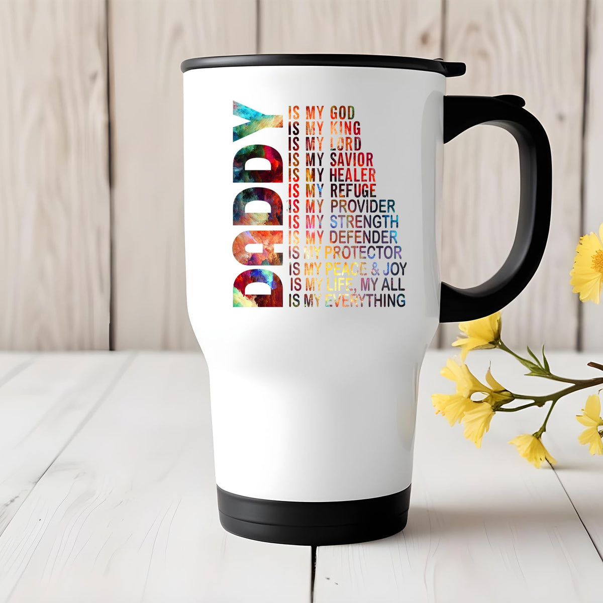 Daddy Is My God travel mug on a white wooden table with yellow flowers