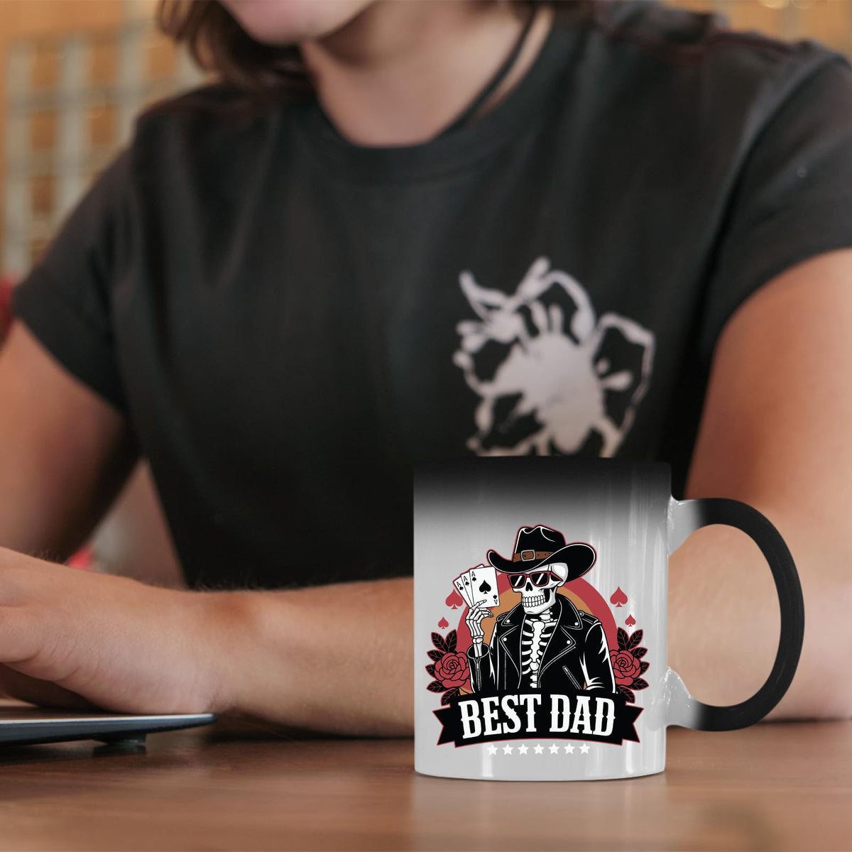 Best Dad skeleton cowboy colour changing mug on a desk beside a laptop