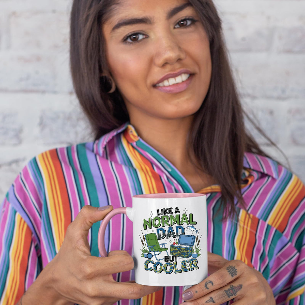 Woman in a striped shirt holding the Like a Normal Dad But Cooler colour handle mug