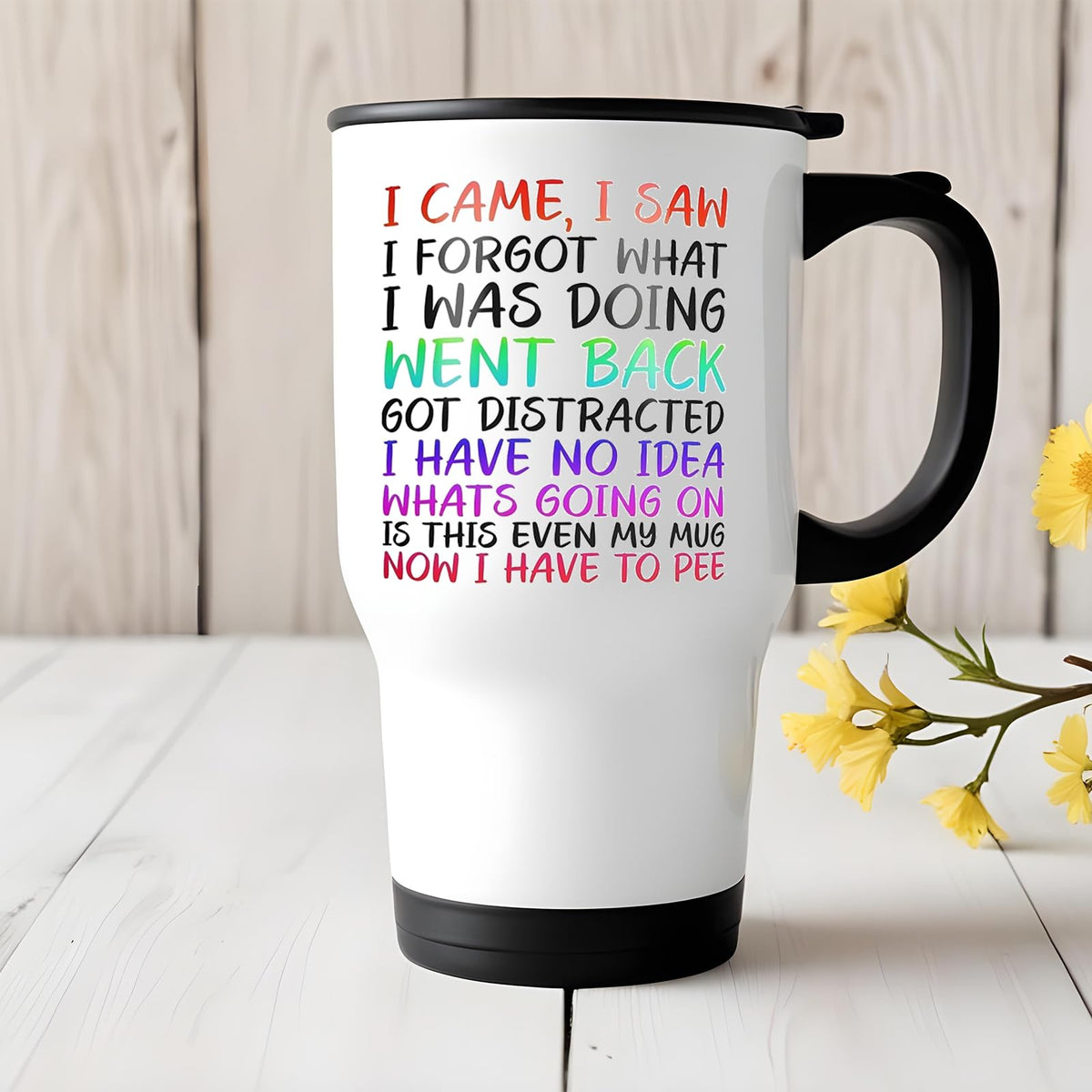 I Came I Saw I Forgot travel mug on a white wooden table with yellow flowers