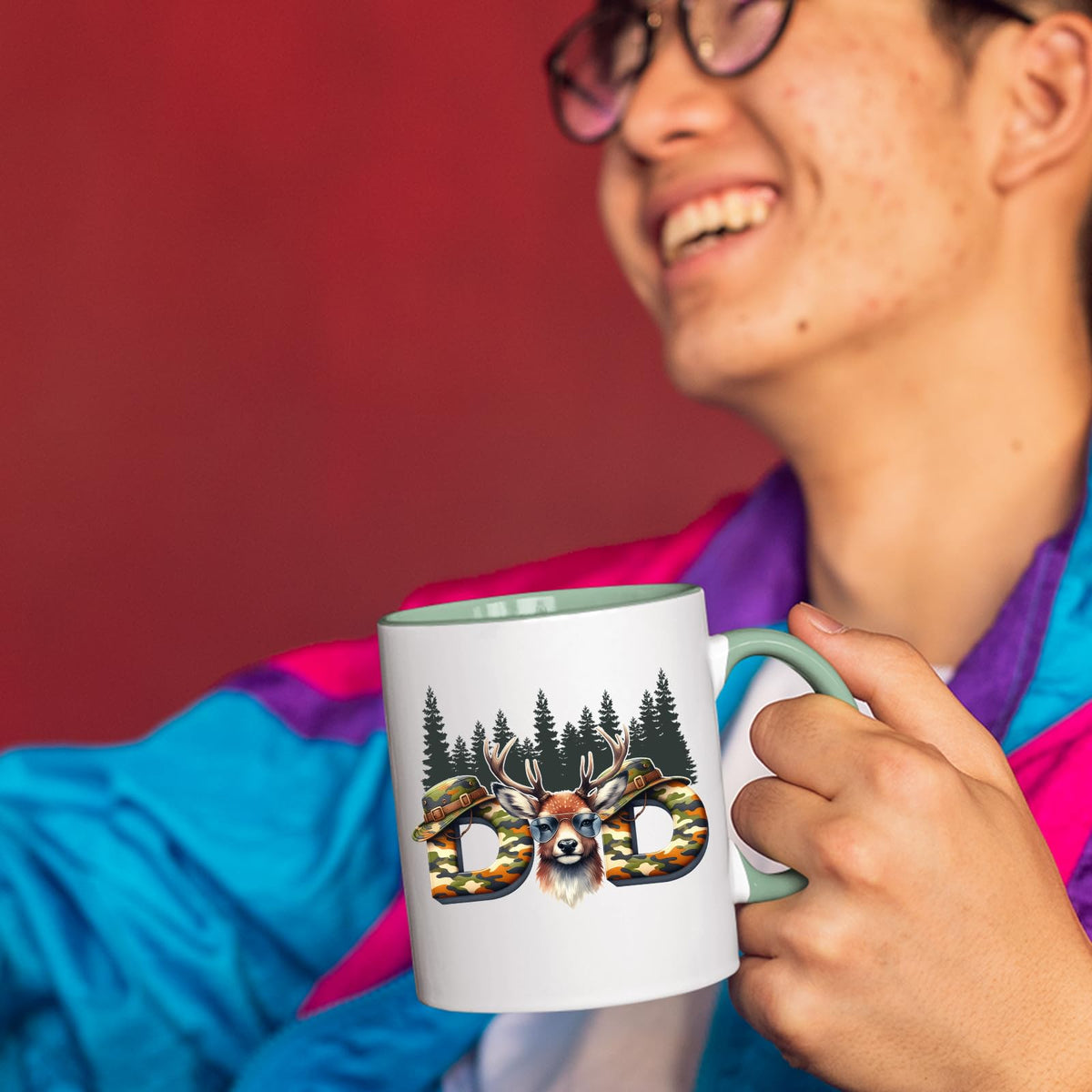 Smiling person in a colourful jacket holding the Hunting Dad deer mug with a light green handle