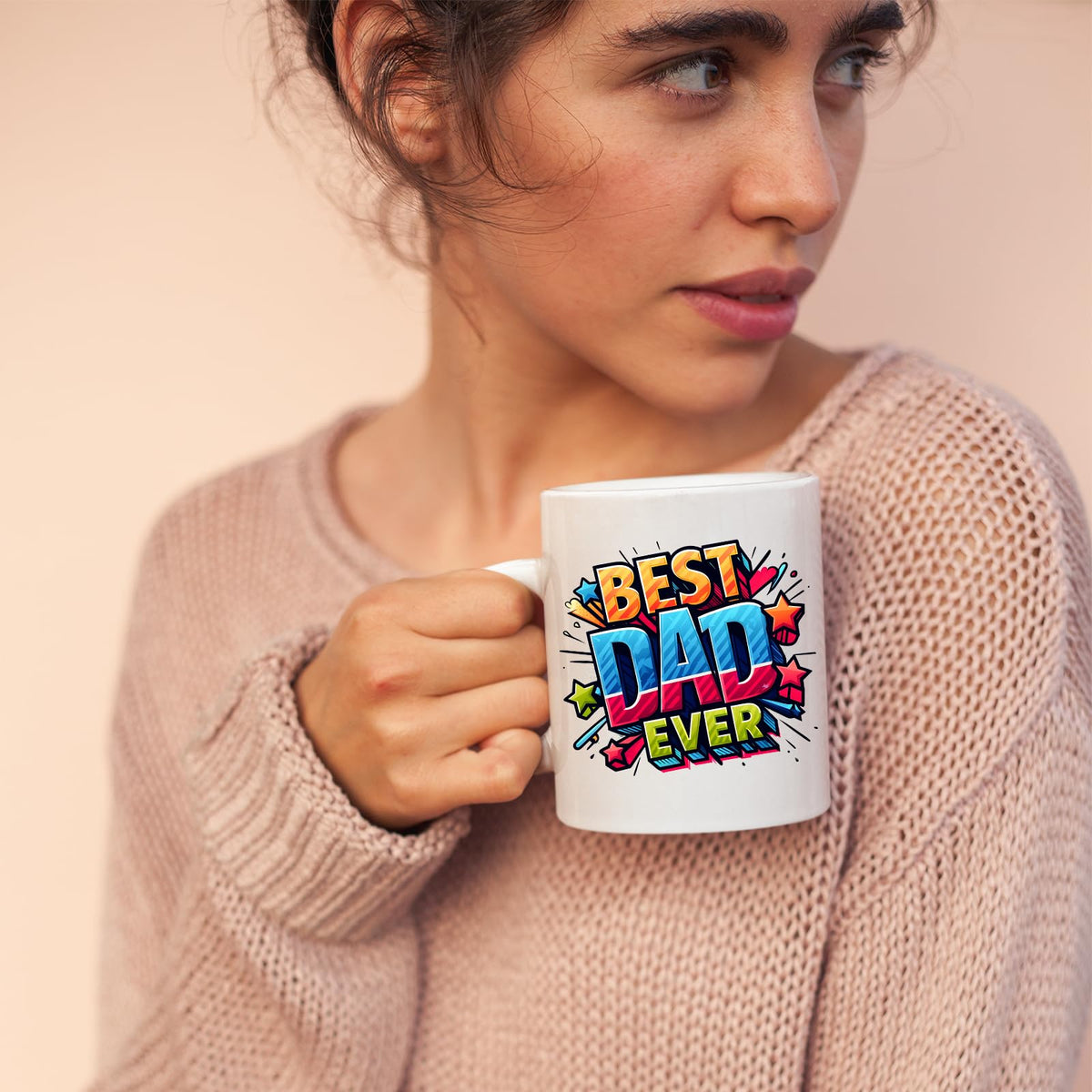 Woman in a pink jumper holding the Best Dad Ever comic mug