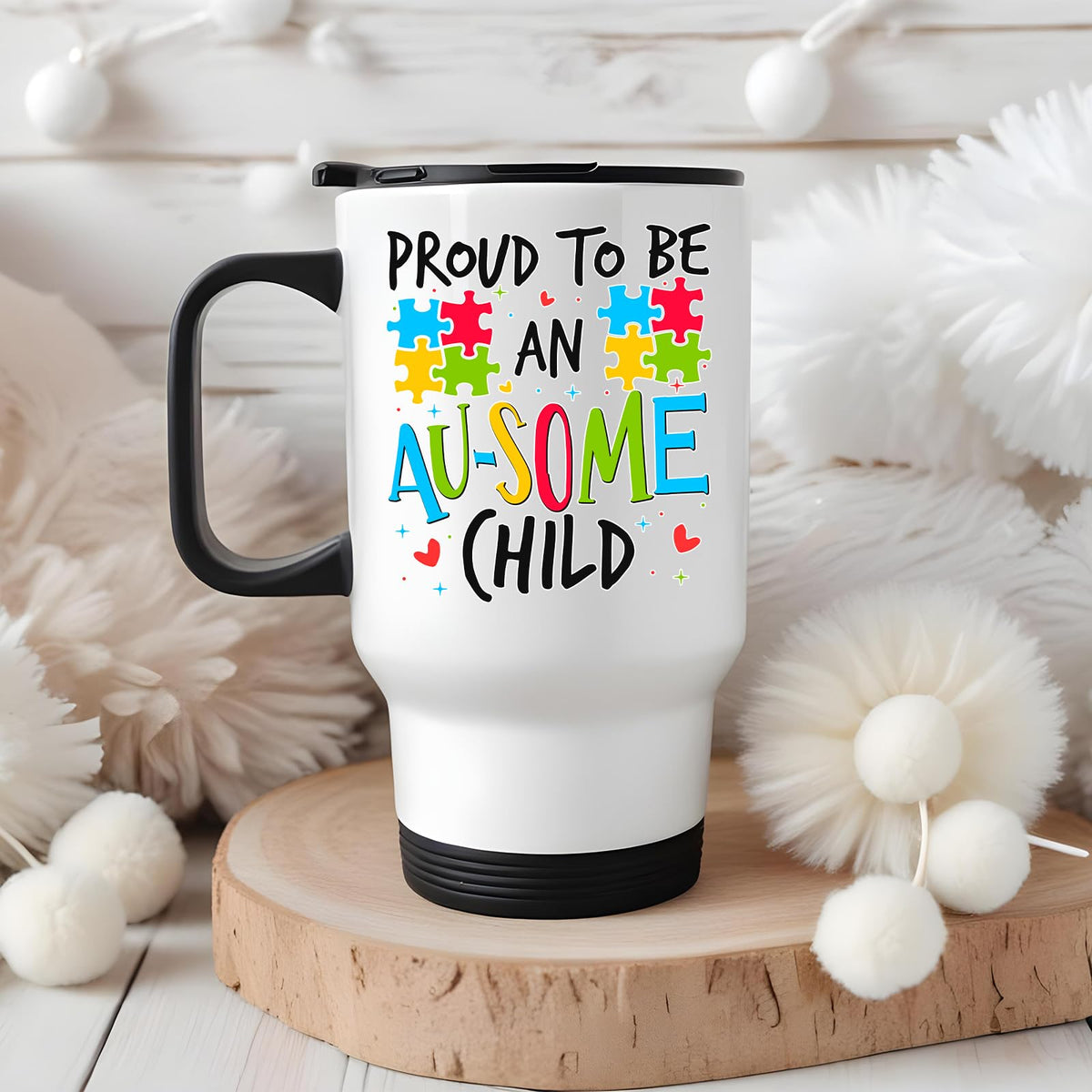 Proud to Be an Au-Some Child travel mug on a wooden slice with white pom-poms