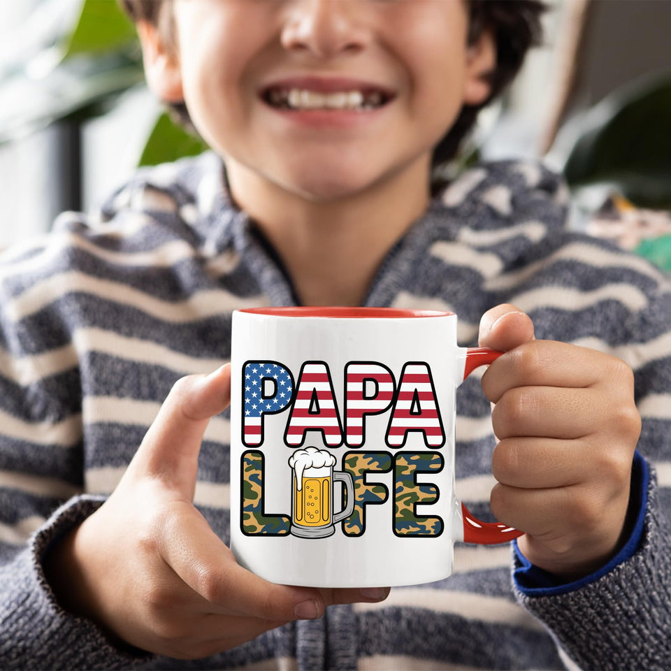 Smiling child holding the Papa Life mug with a red handle