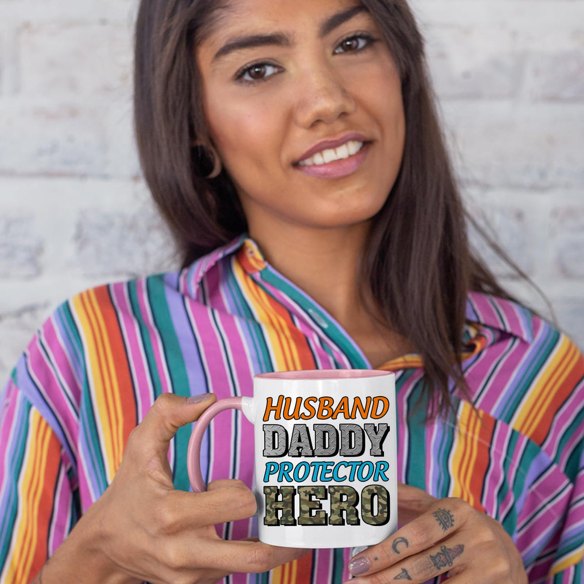 Woman in a striped shirt holding the Husband Daddy Protector Hero camo colour handle mug