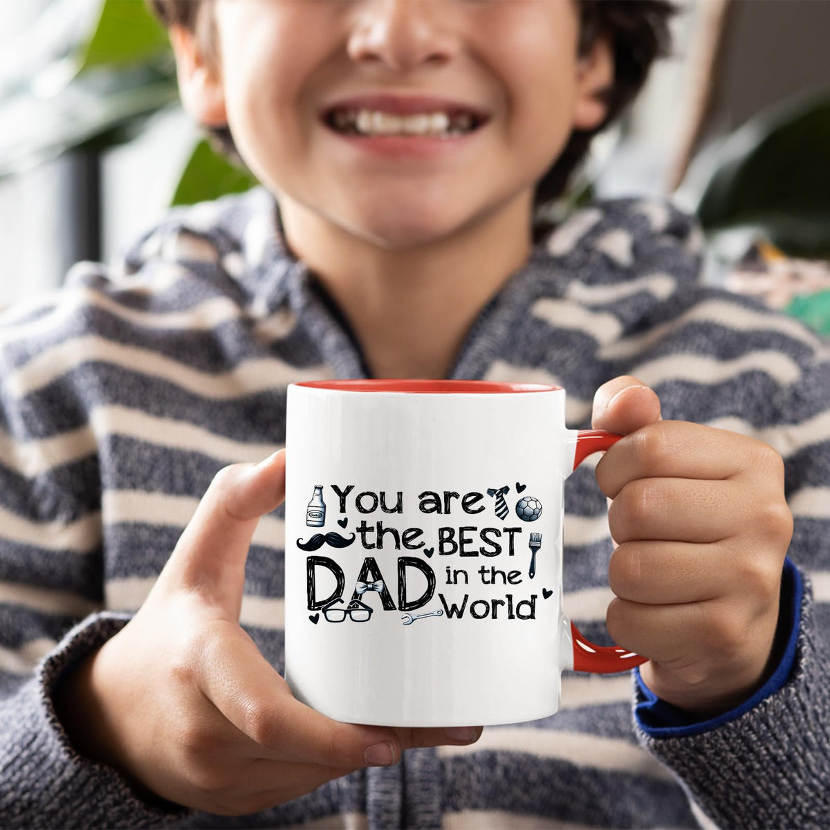 Smiling child holding the Best Dad in the World sketch mug with a red handle