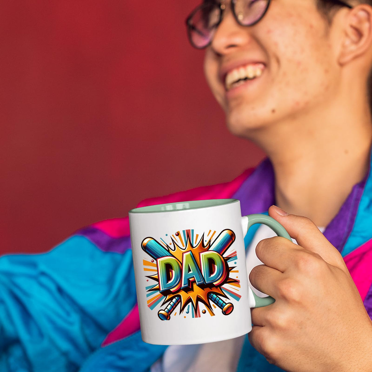 Smiling person in a colourful jacket holding the DAD baseball bats mug with a light green handle