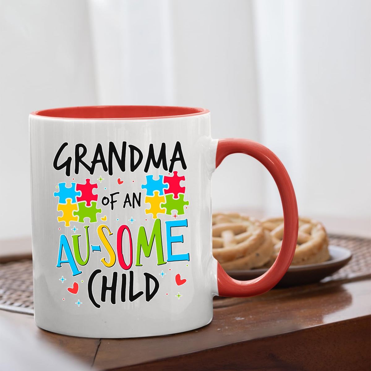 Grandma of an Au-Some Child mug with a red handle beside biscuits
