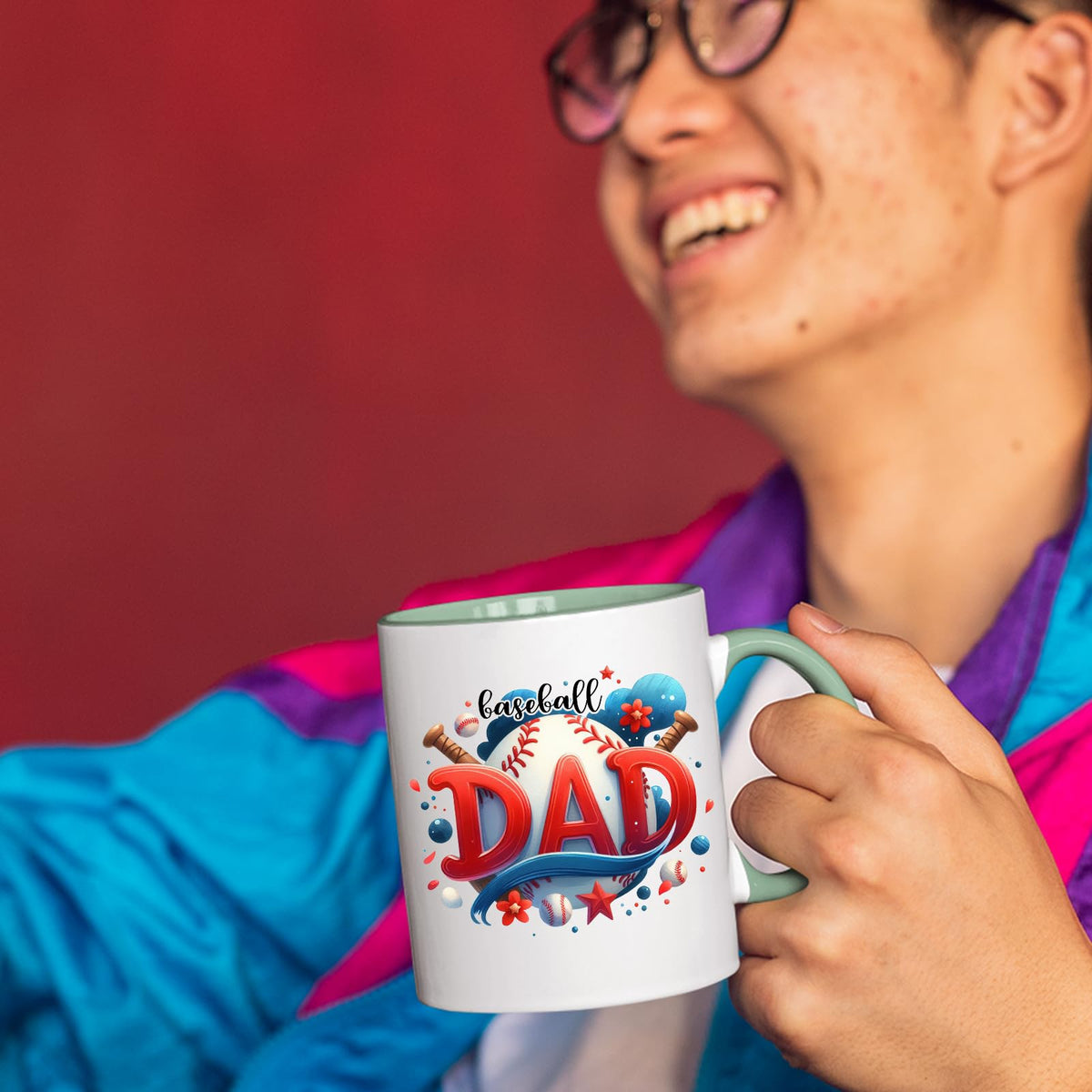 Smiling person in a colourful jacket holding the Baseball Dad mug with a light green handle