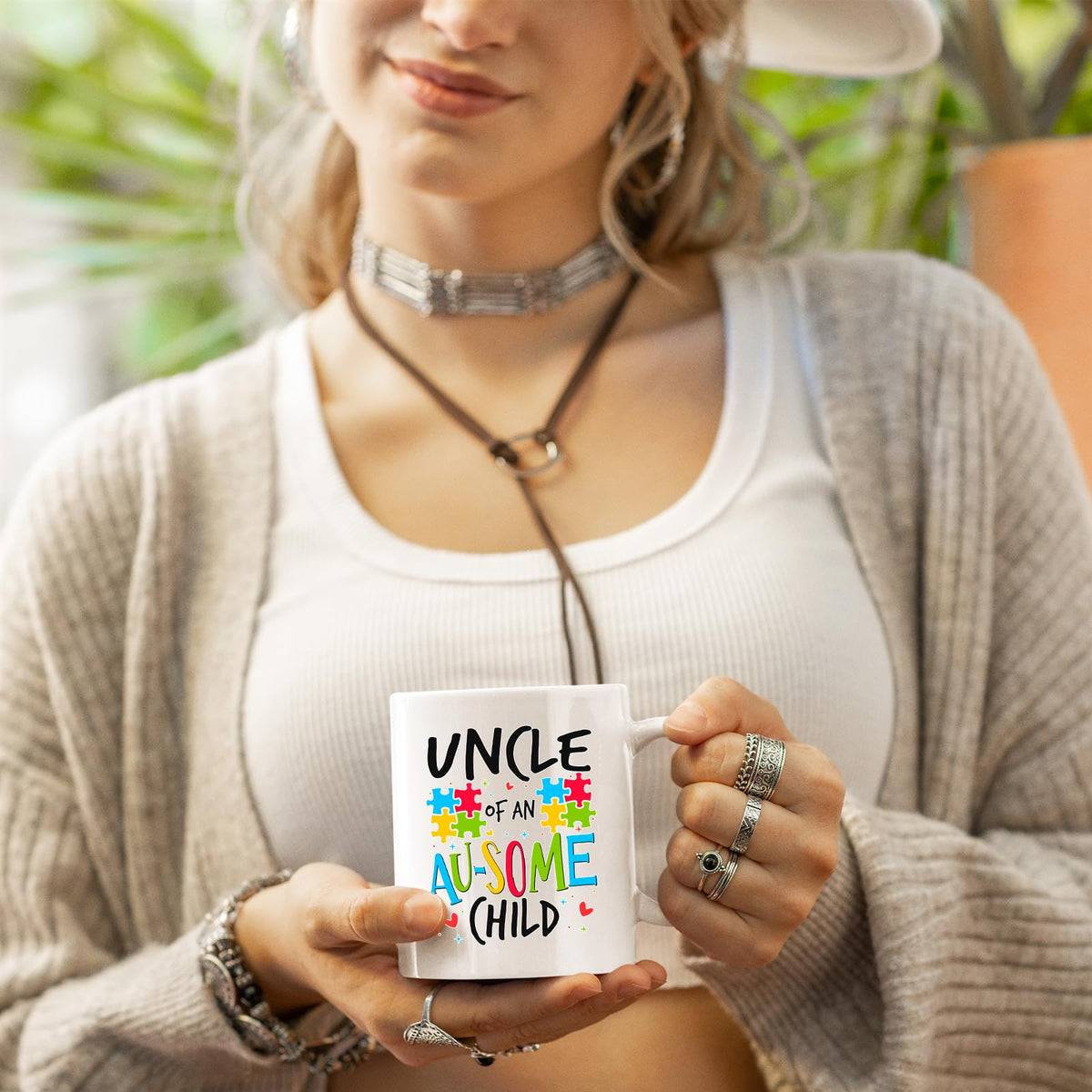 Woman in a cardigan holding the Uncle of an Au-Some Child mug