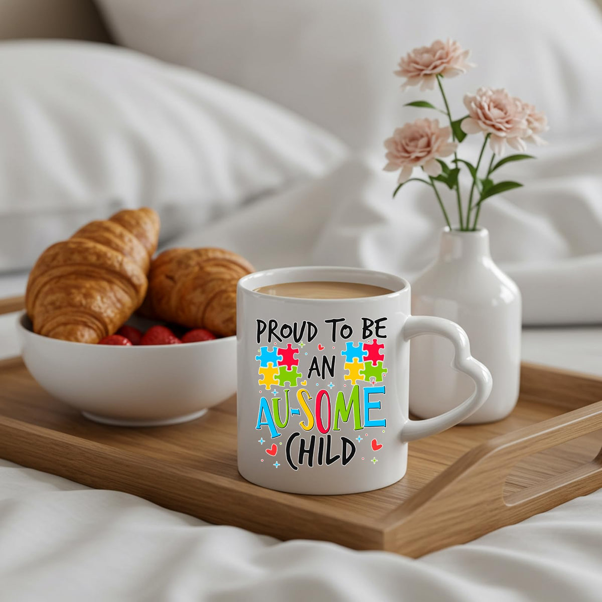 Proud to Be an Au-Some Child heart-handle mug on a breakfast tray with croissants and flowers
