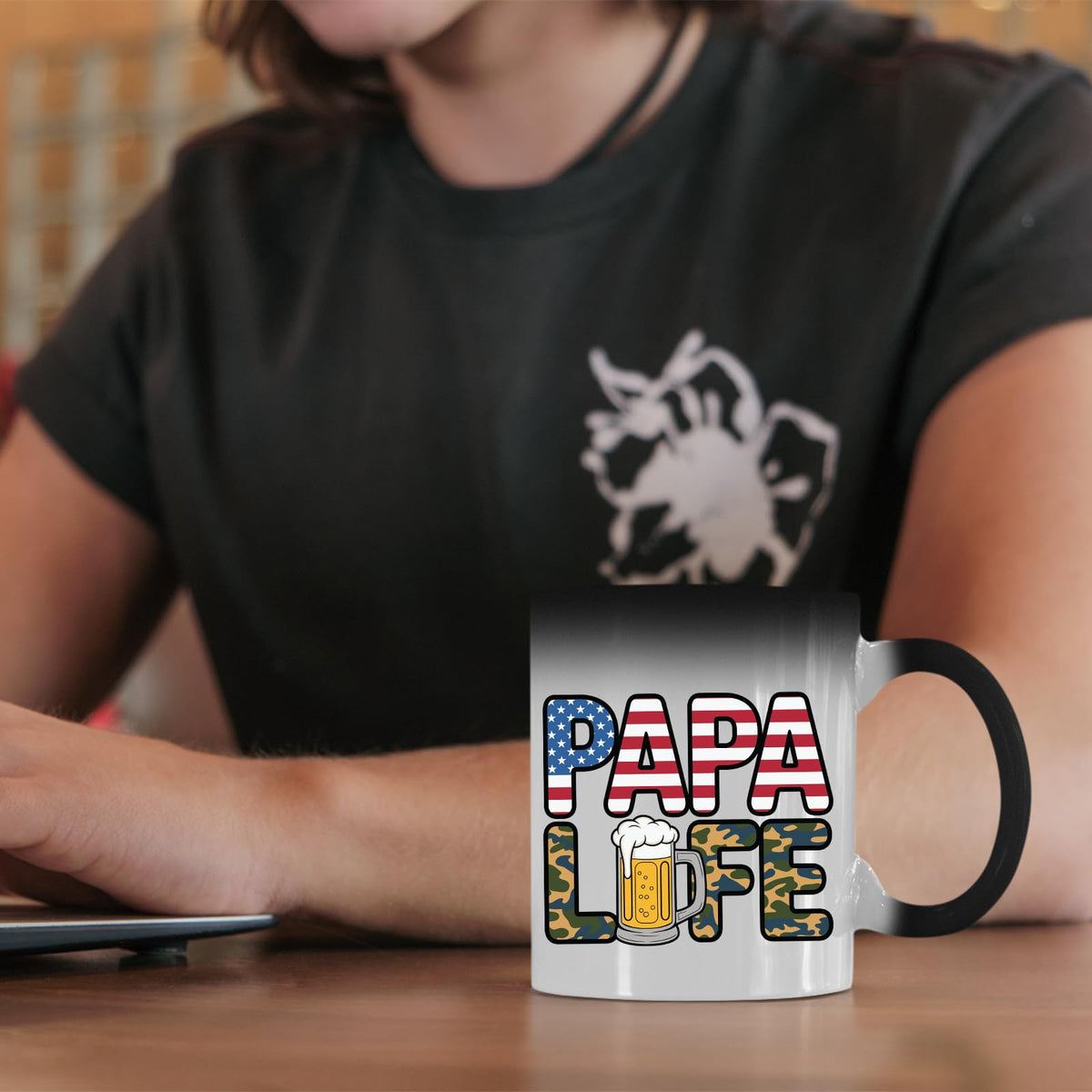 Papa Life colour changing mug on a desk beside a laptop