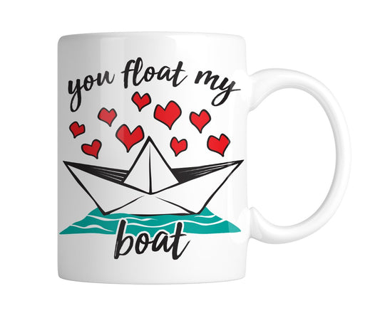 White mug with a paper boat, red hearts and “You Float My Boat”, handle on the right