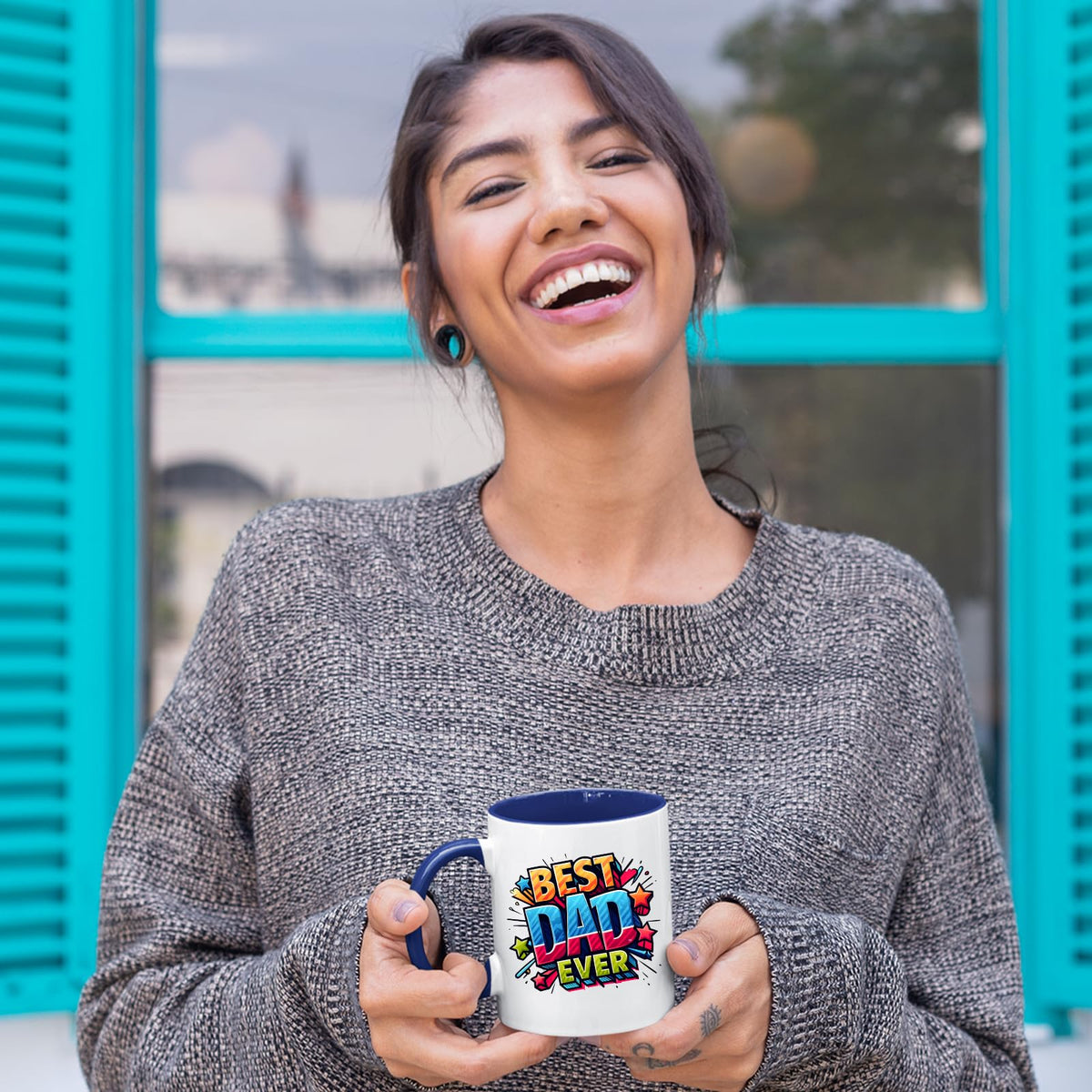 Laughing woman holding the Best Dad Ever comic mug with a dark blue handle