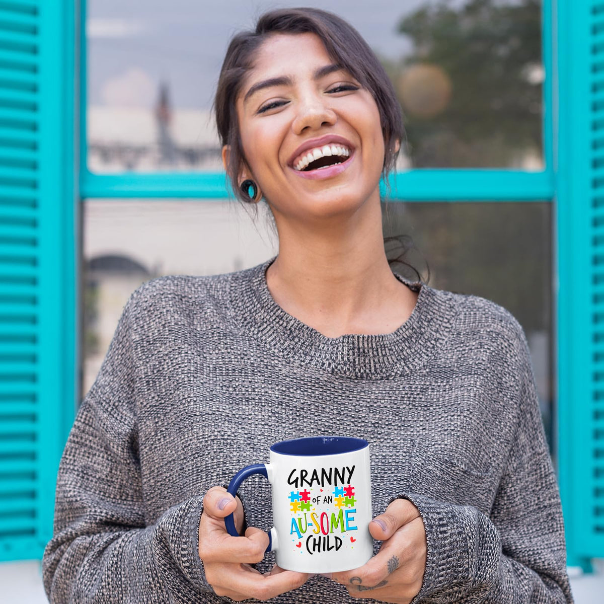 Laughing woman holding the Granny of an Au-Some Child mug with a dark blue handle