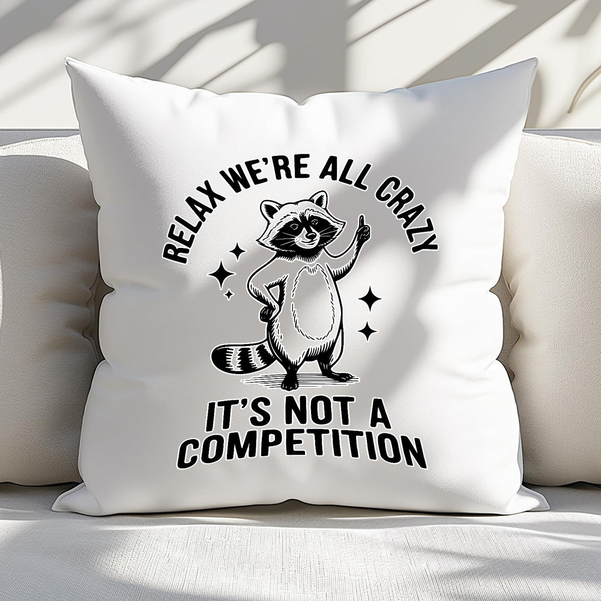 Relax We’re All Crazy raccoon cushion on a white sofa