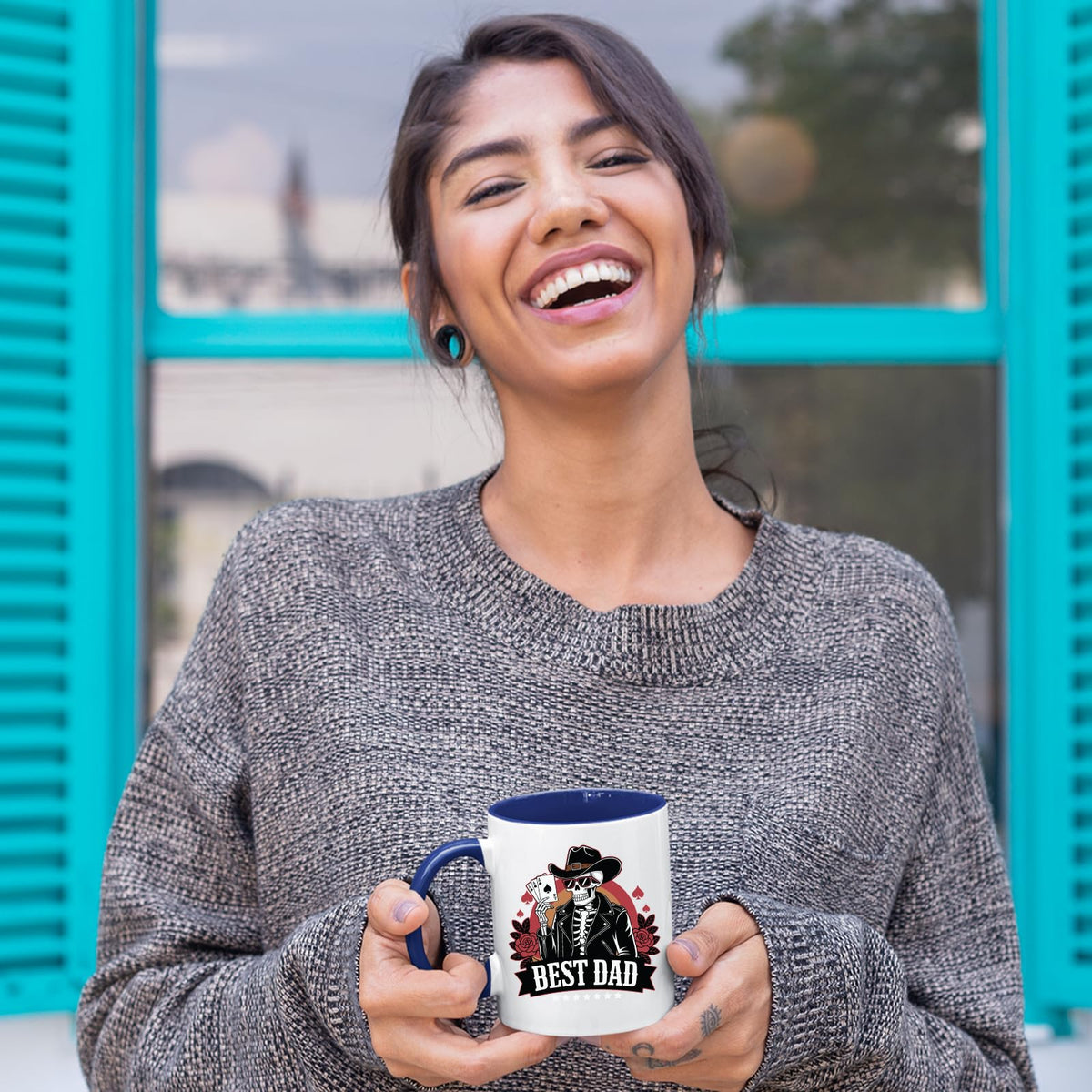 Laughing woman holding the Best Dad skeleton cowboy mug with a dark blue handle