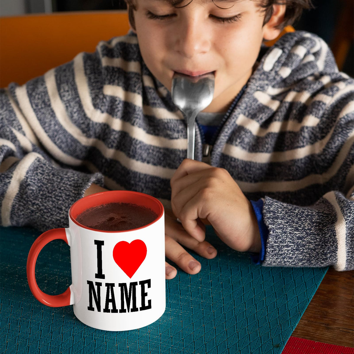 Boy with a spoon next to an I love name mug with a red handle