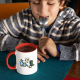 Child with a spoon next to the Reel Cool Dad mug with a red handle