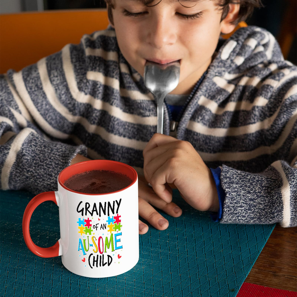 Child with a spoon next to the Granny of an Au-Some Child mug with a red handle