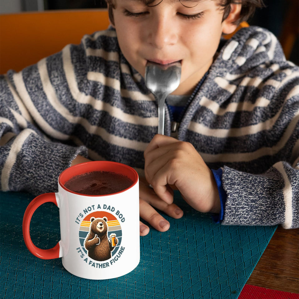 Child with a spoon next to the Dad Bod bear mug with a red handle
