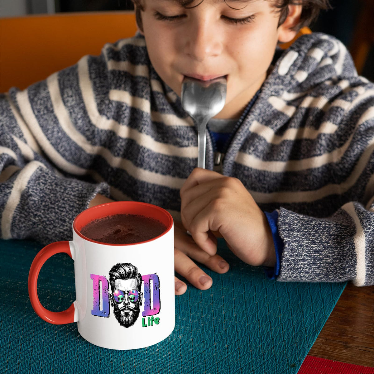 Child with a spoon next to the Dad Life bearded dad mug with a red handle