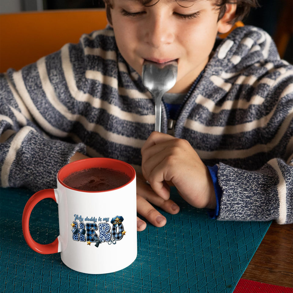 Child with a spoon next to the My Daddy Is My Hero police mug with a red handle
