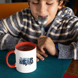 Child with a spoon next to the My Daddy Is My Hero police mug with a red handle