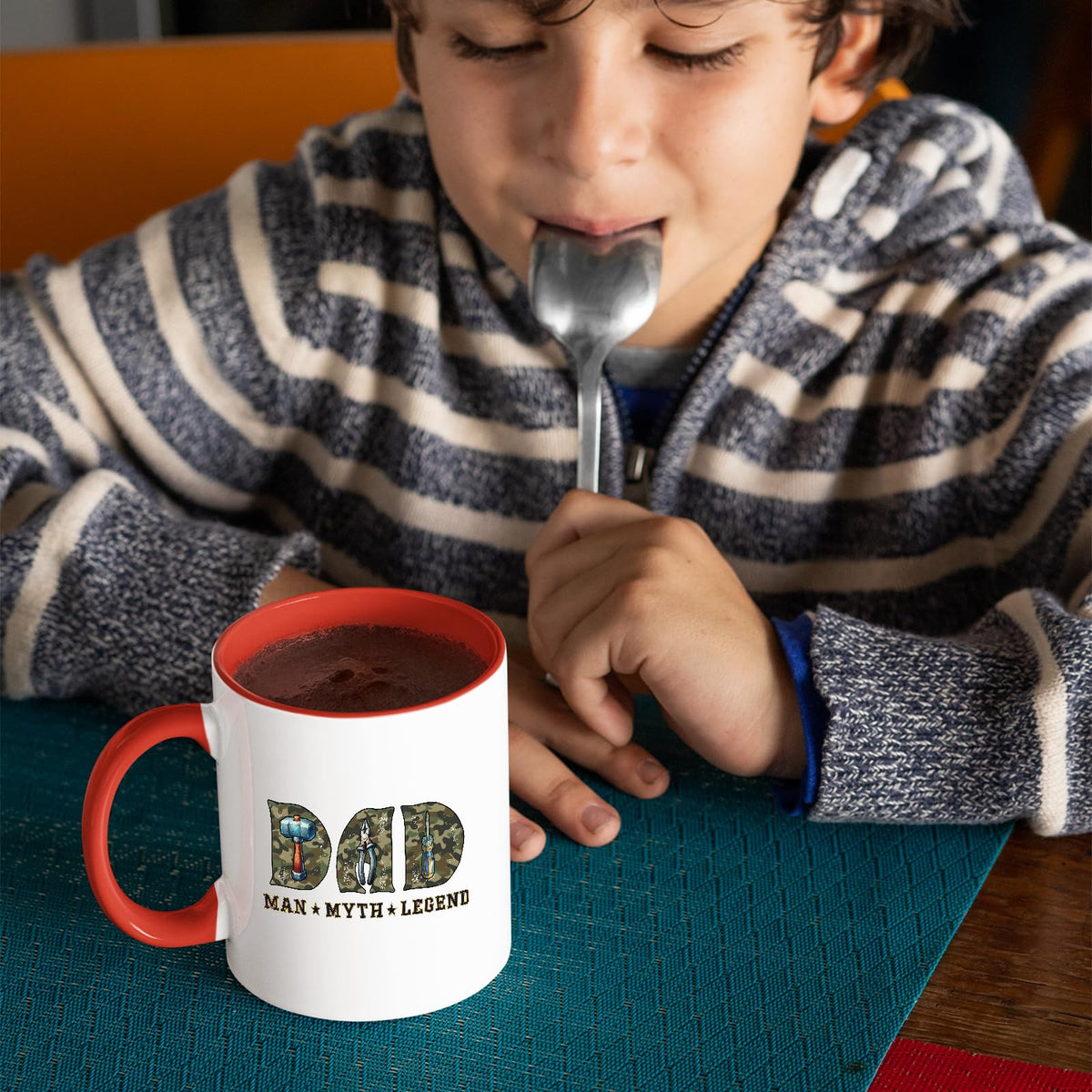 Child with a spoon next to the Dad Man Myth Legend tools mug with a red handle