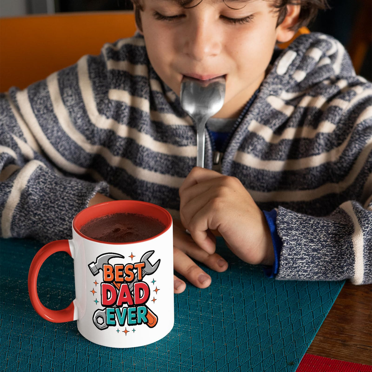 Child with a spoon next to the Best Dad Ever tools mug with a red handle